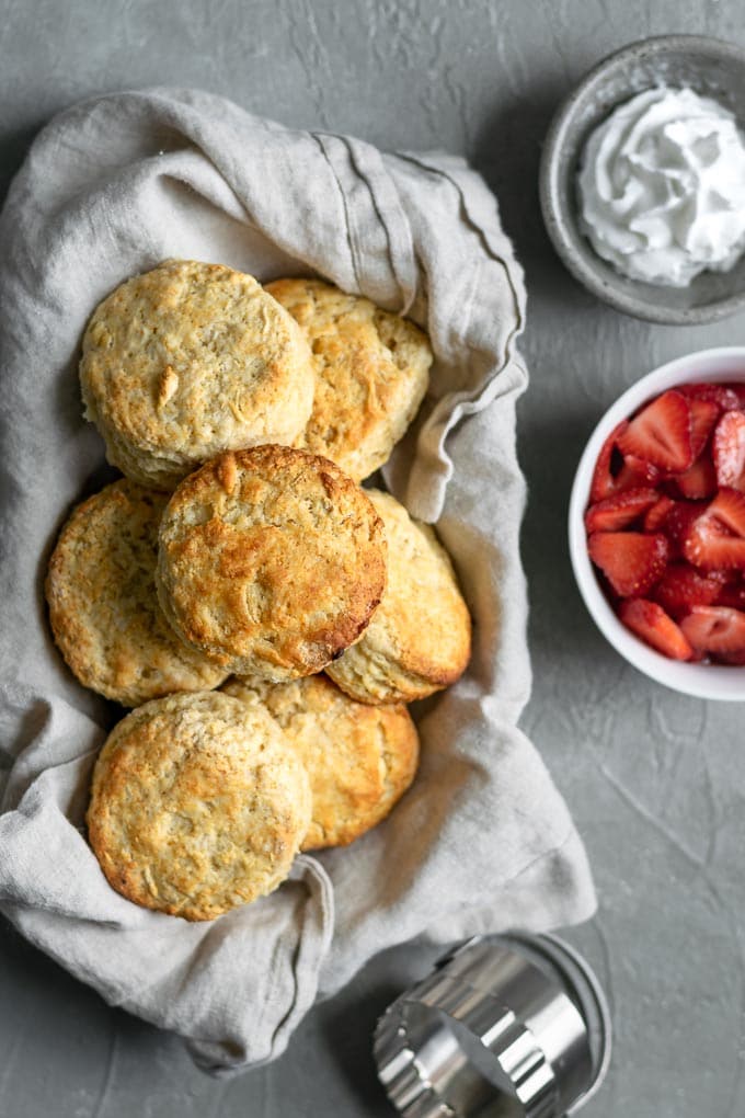 shortbread biscuits, brandy soaked strawberries, and vanilla bean whipped cream waiting to be assembled into strawberry shortcake