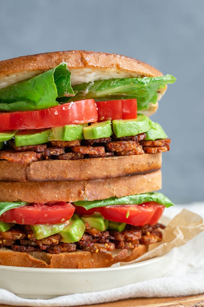 vegan tempeh bacon, lettuce, tomato, and avocado sandwiches closeup