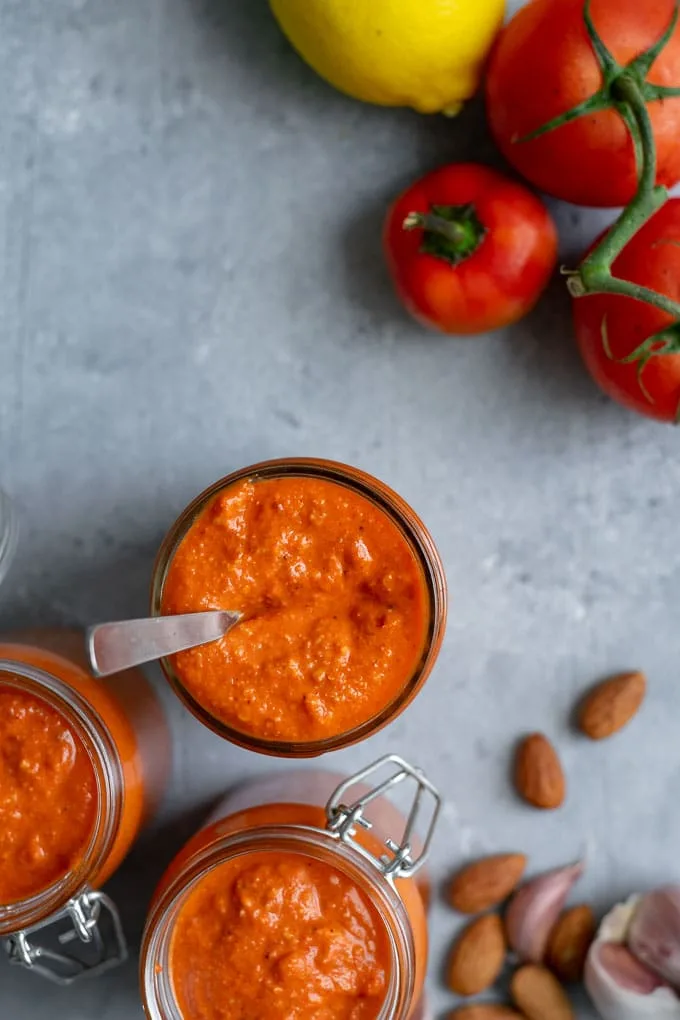 Easy romesco sauce with some of the ingredients: almonds, garlic, tomatoes, a chile pepper, and lemon