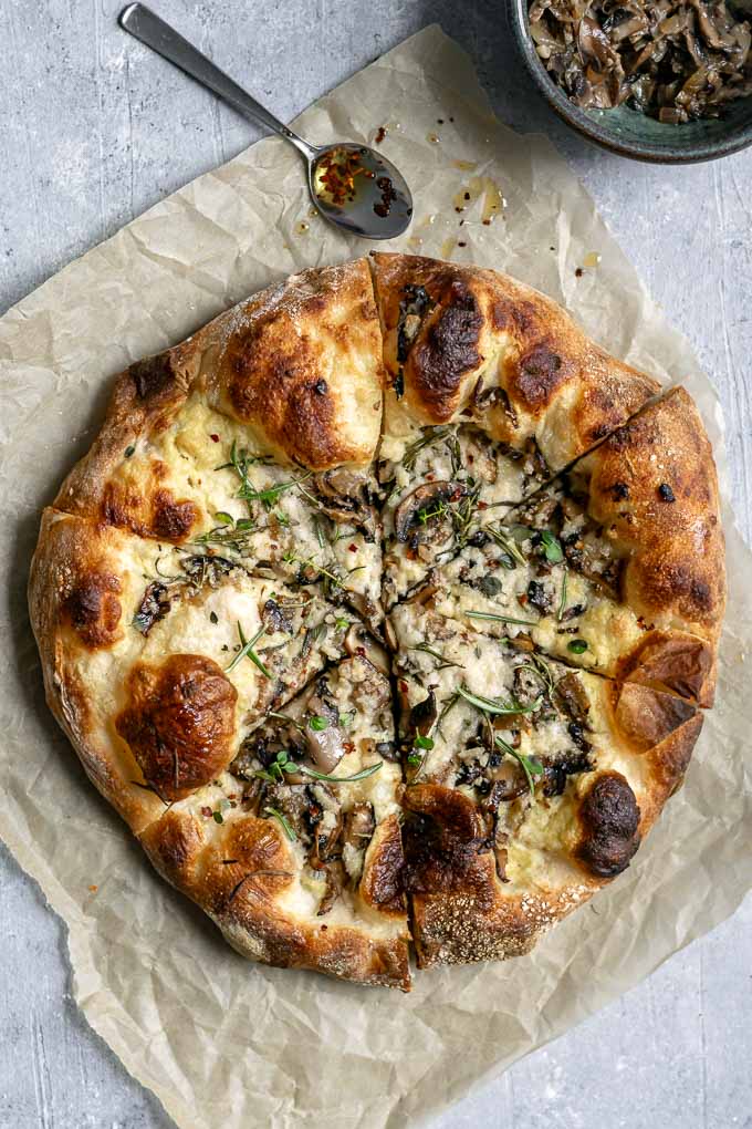 vegan caramelized mushroom pizza with garlic white sauce and fresh rosemary