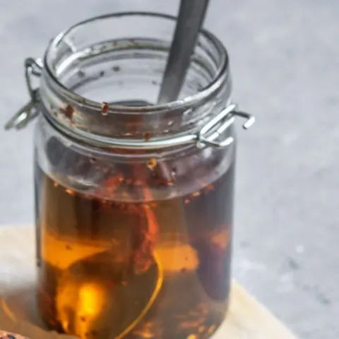 homemade chili oil in glass jar with a spoon