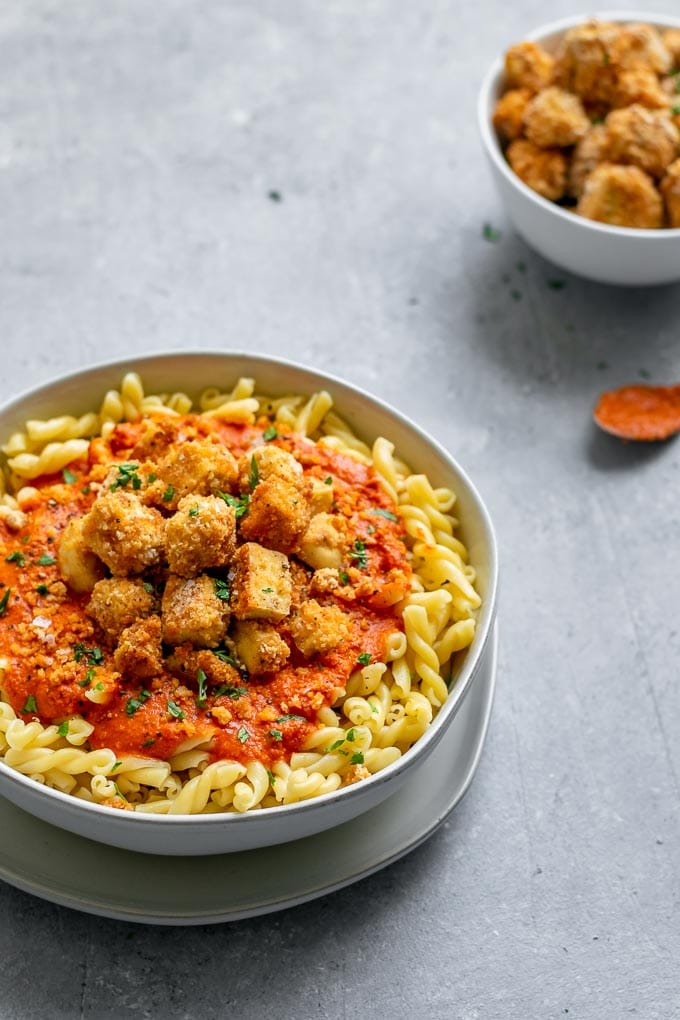 Pasta romesco topped with crispy baked tofu and seasoned toasted breadcrumbs