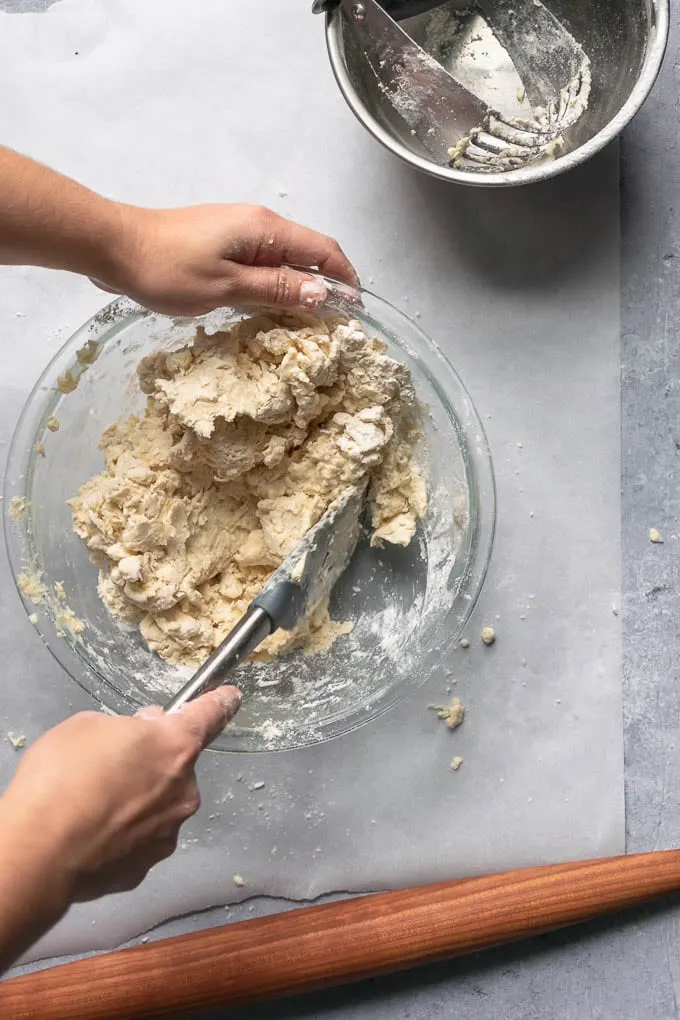 using a spatula to fold the dough together