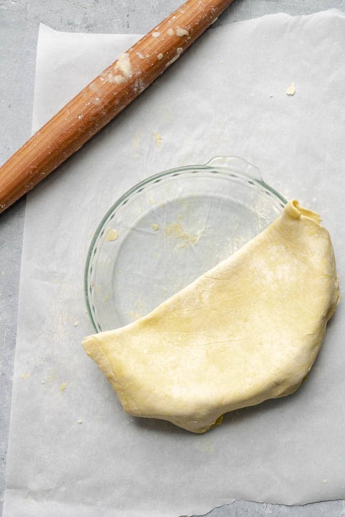 Transferring pie dough to pie dish, with the dough folded in half