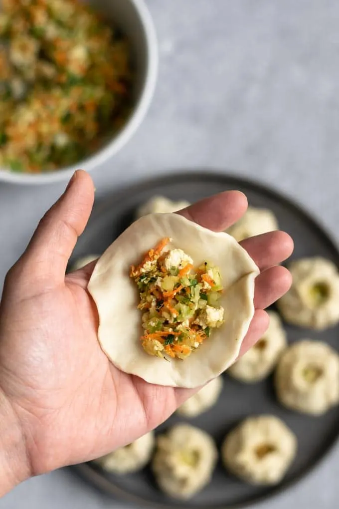 shaping Tibetan vegetable momos into a round dumpling