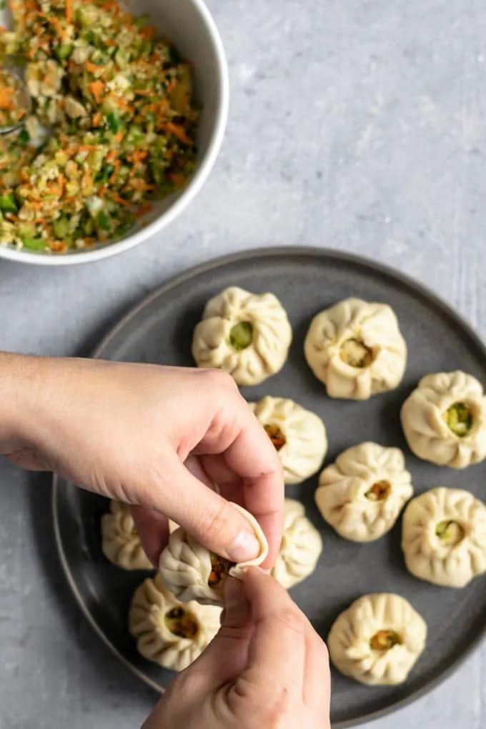 shaping Tibetan vegetable momos into a round dumpling