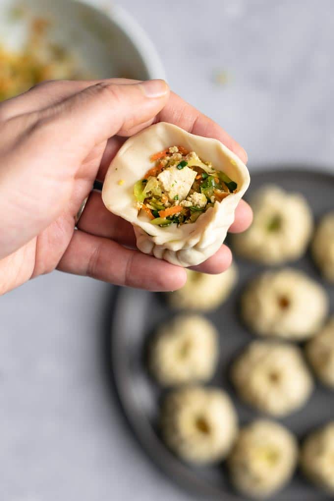 shaping Tibetan vegetable momos into a round dumpling