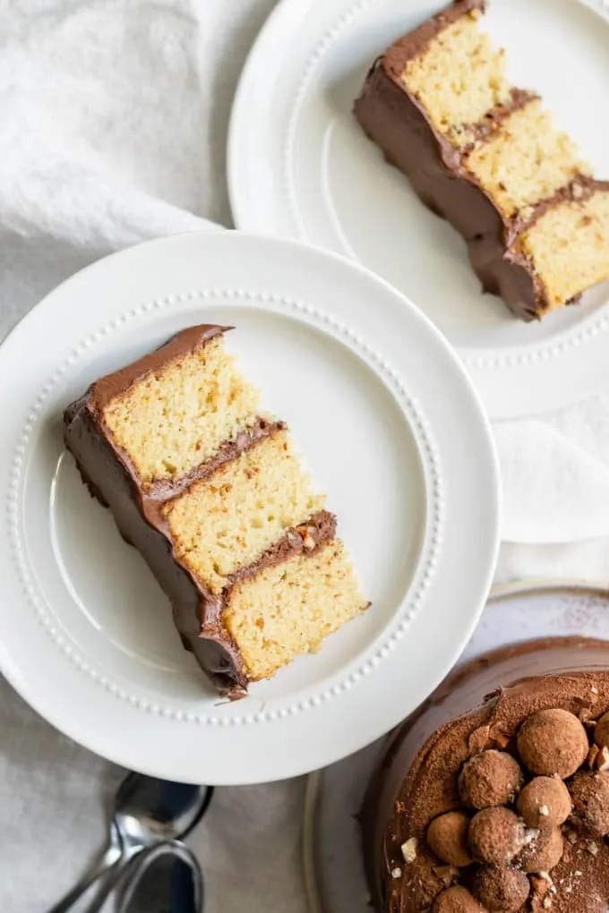 two slices of vegan hazelnut cake frosted with a whipped chocolate ganache