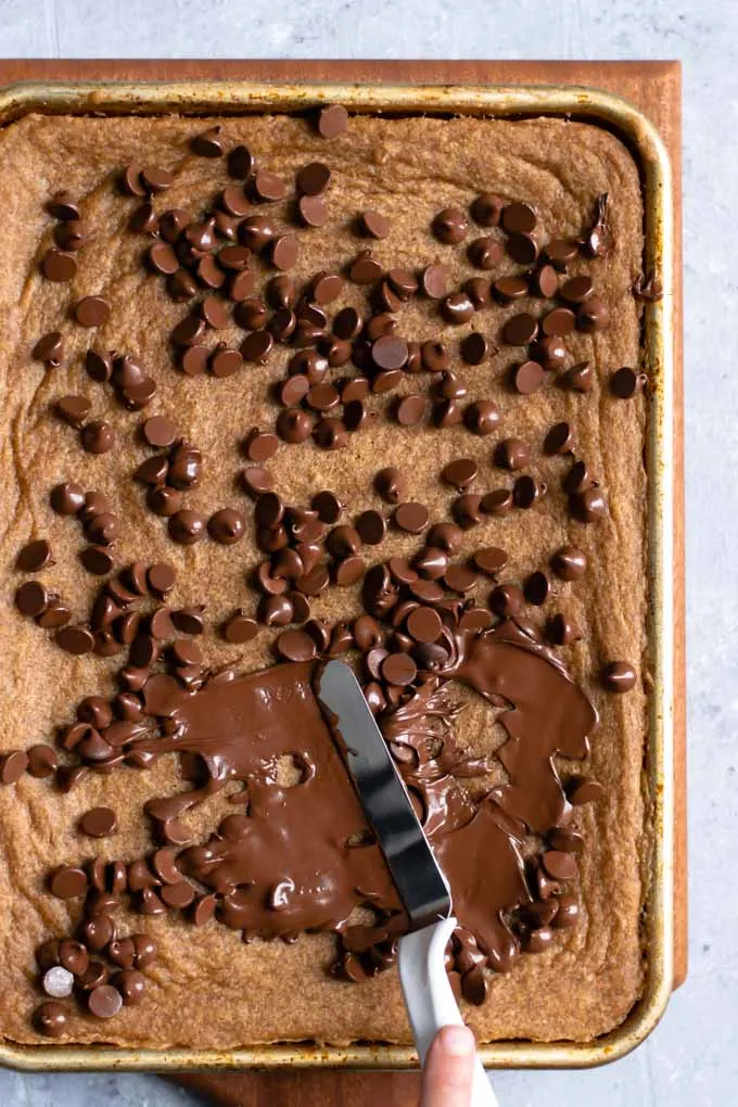 spreading melted chocolate over the vegan mocha cinnamon bars