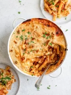 vegan baked ziti in casserole dish with two plates served
