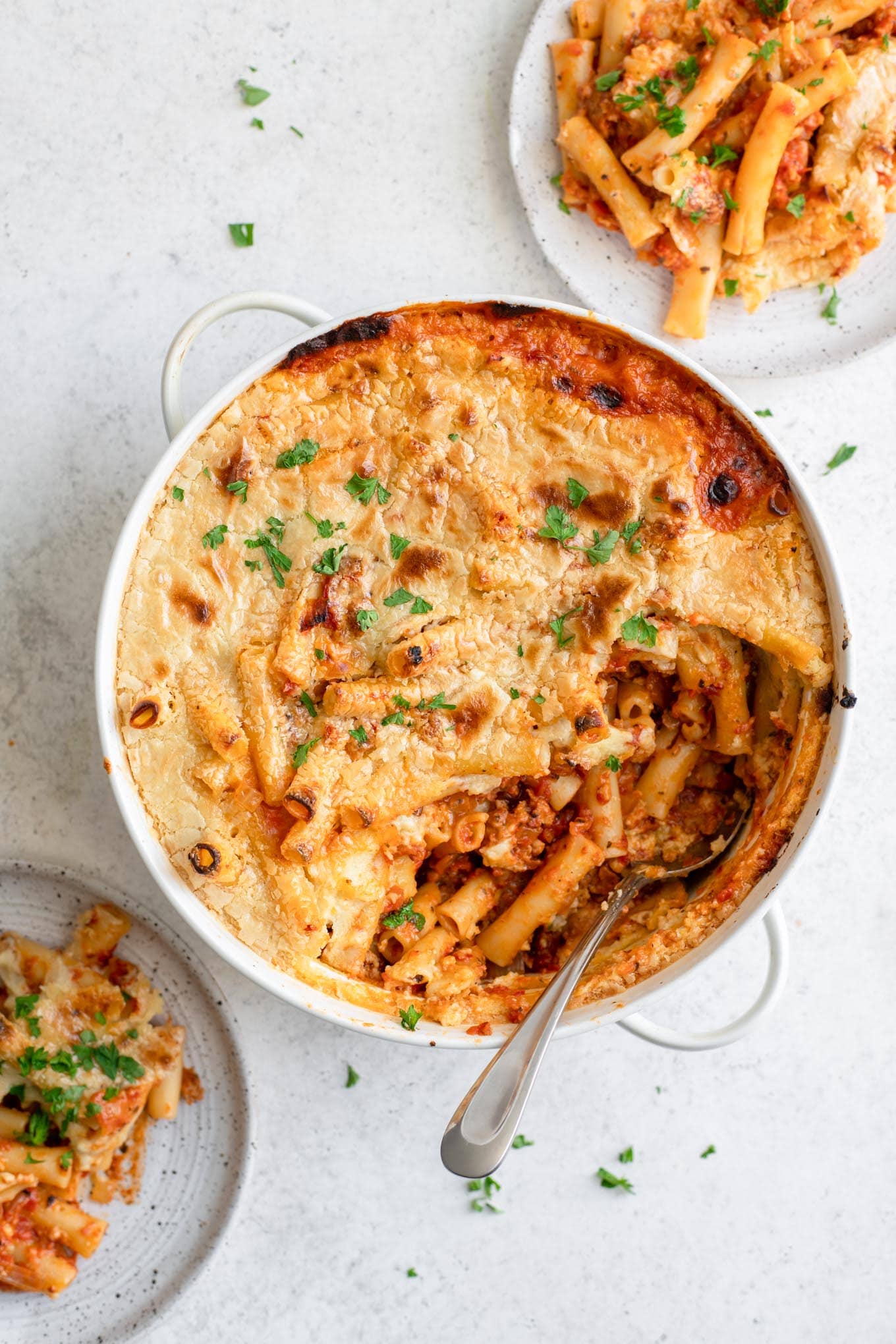 vegan baked ziti in casserole dish with two plates served