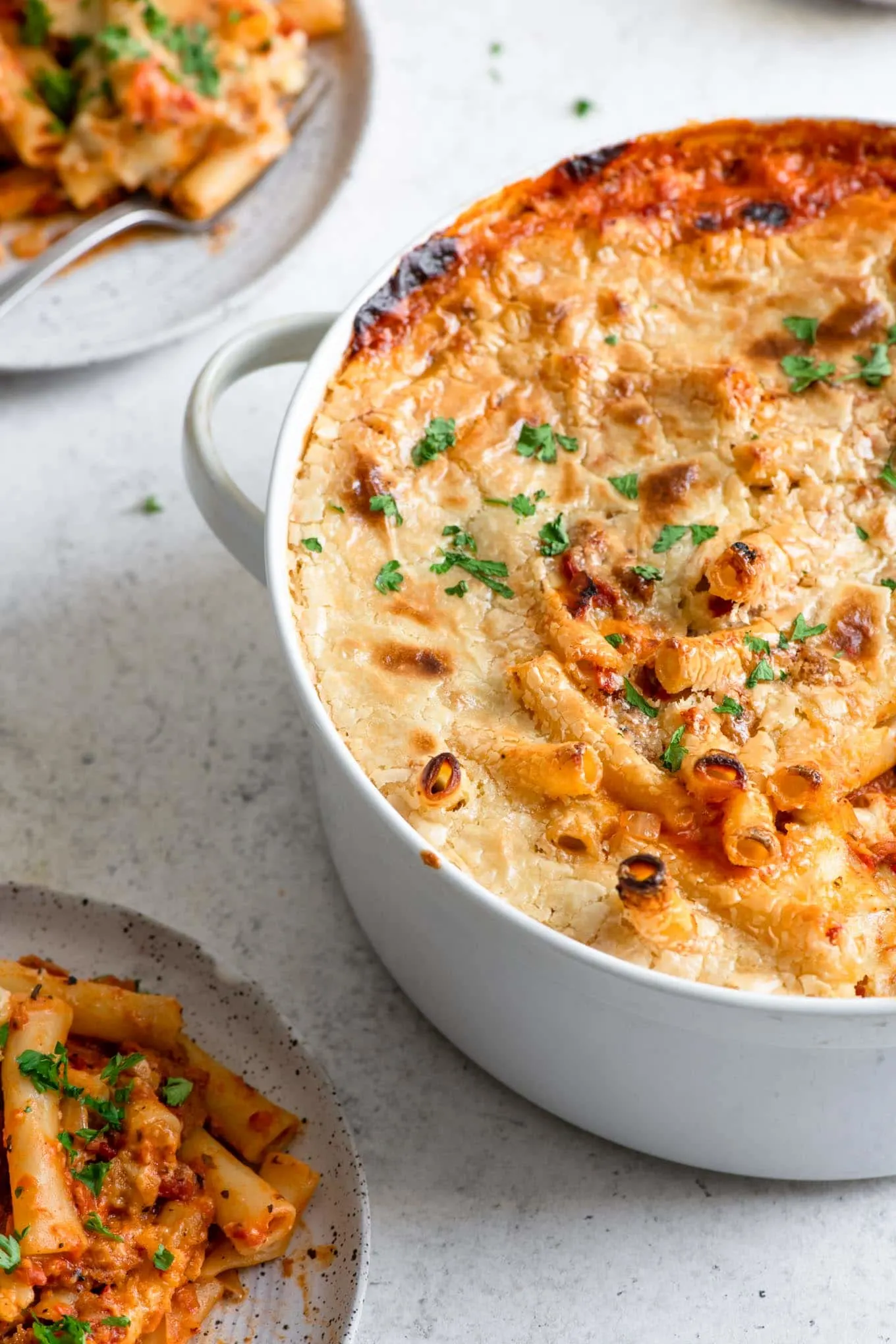 pasta in casserole dish with two plates served