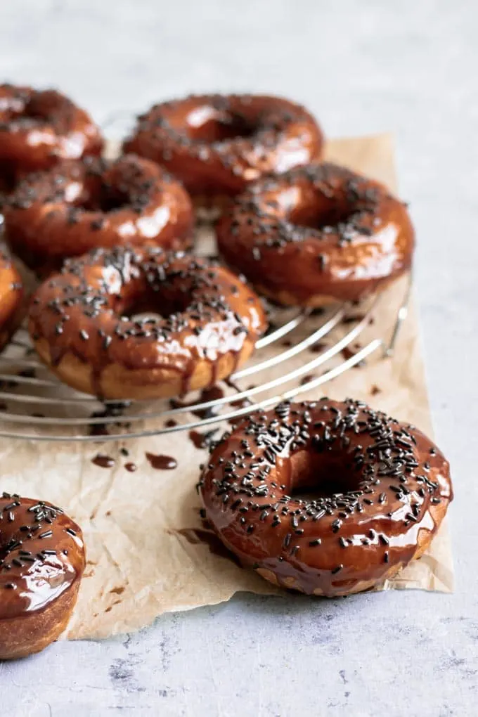 vegan chocolate glazed doughnuts with chocolate sprinkles, viewed from an angle