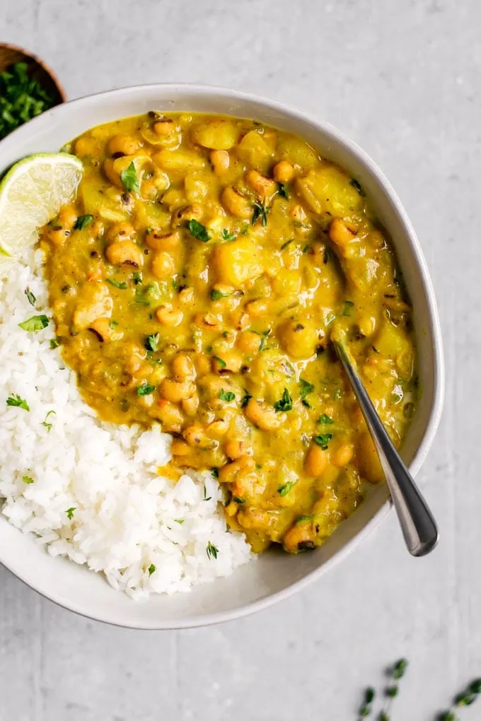 Jamaican black-eyed pea curry served with lime wedges and rice
