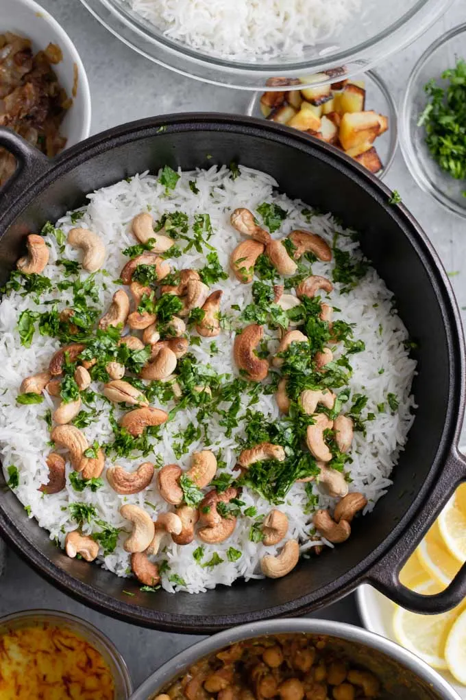 First layer of rice, cashews, mint, and cilantro for Sindhi vegetable biryani