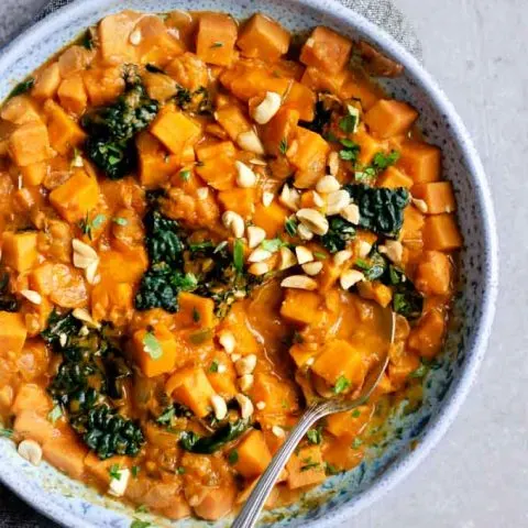 A large bowlful of West African curry sweet potato, kale, and peanut stew