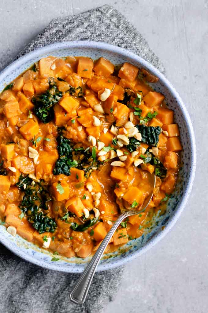 A large bowlful of West African curry sweet potato, kale, and peanut stew