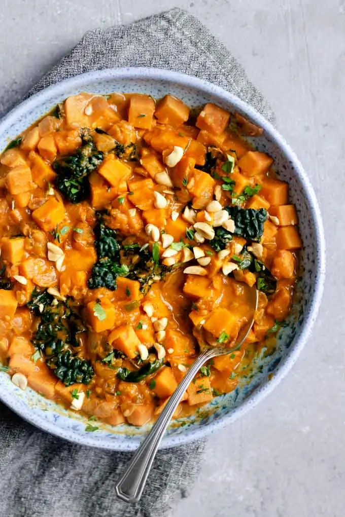 A large bowlful of West African curry sweet potato, kale, and peanut stew