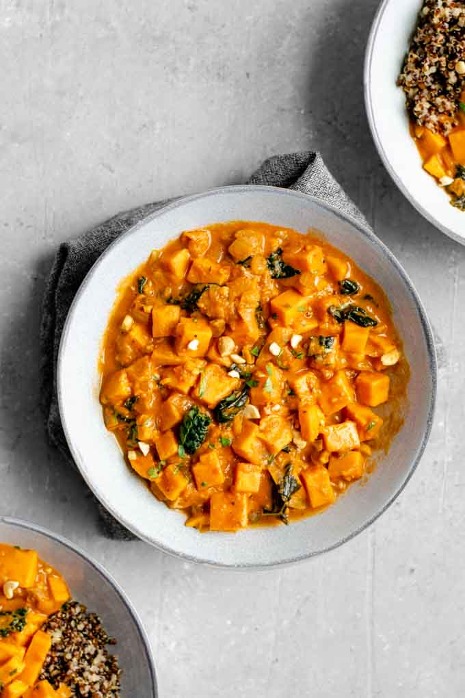 Three bowls of West African curry sweet potato, kale, and peanut stew