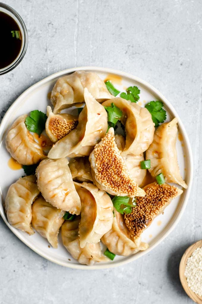 Gochujang tofu dumplings with a chili oil drizzle and cilantro to garnish