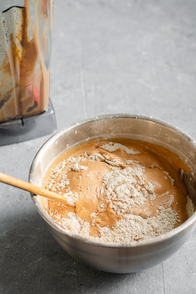 Mixing in the wet and dry ingredients with a wooden spoon