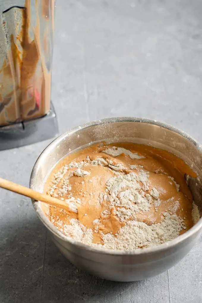 Mixing in the wet and dry ingredients with a wooden spoon