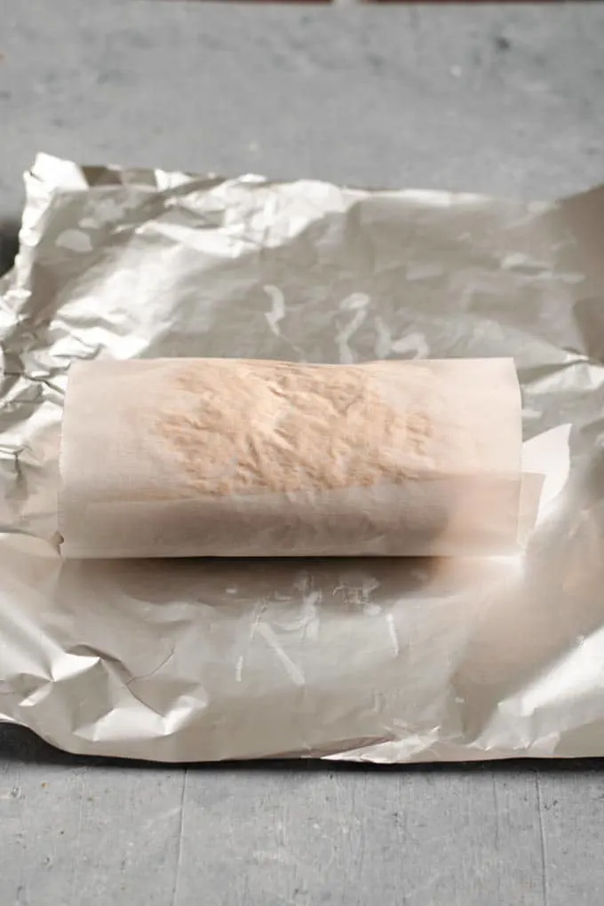 Seitan dough wrapped in the parchement paper and ready to be wrapped in the foil