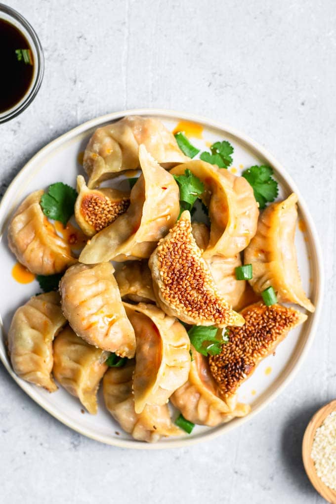 gochujang tofu dumplings drizzled with chili oil and garnished with cilantro and green onion