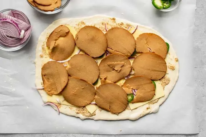 stromboli topped with vegan cheese, jalapeño, red onion, and vegan deli slices