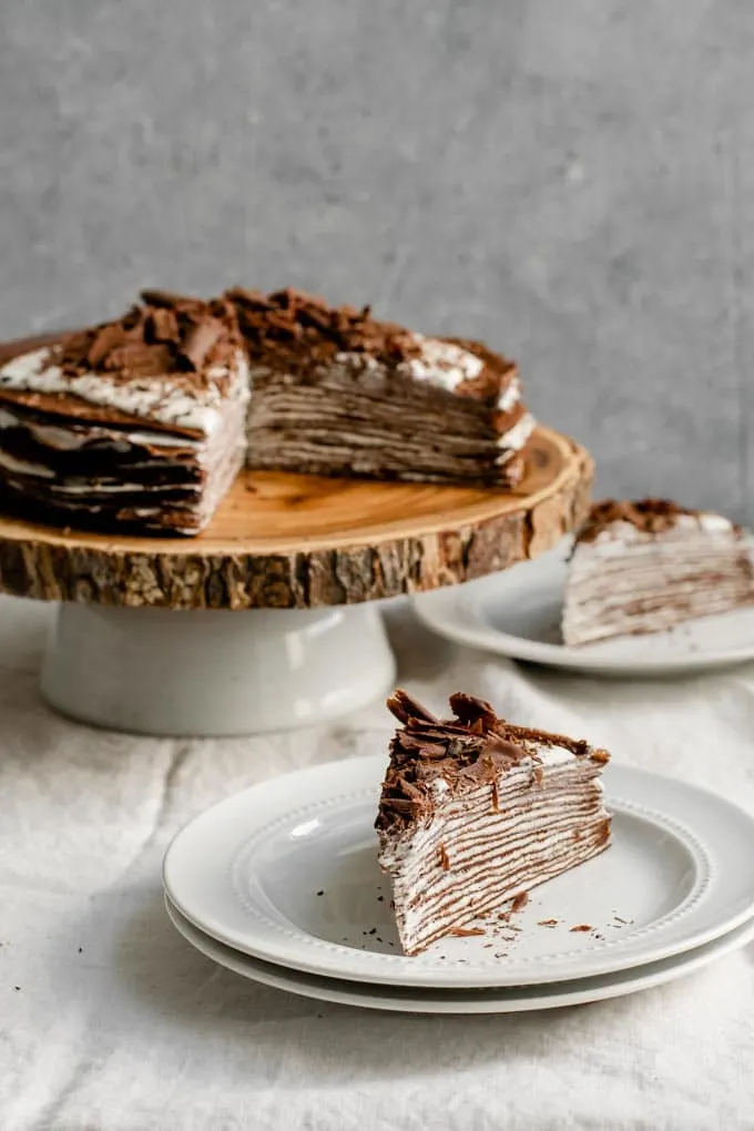 slices of vegan dark chocolate crepe cake with whipped whiskey cream
