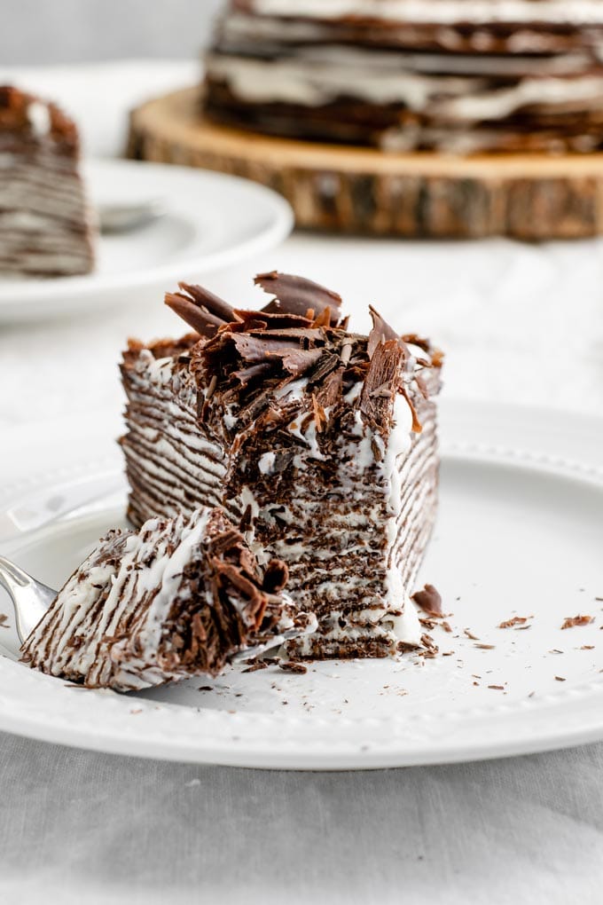 close up of slice of crepe cake with a forkful