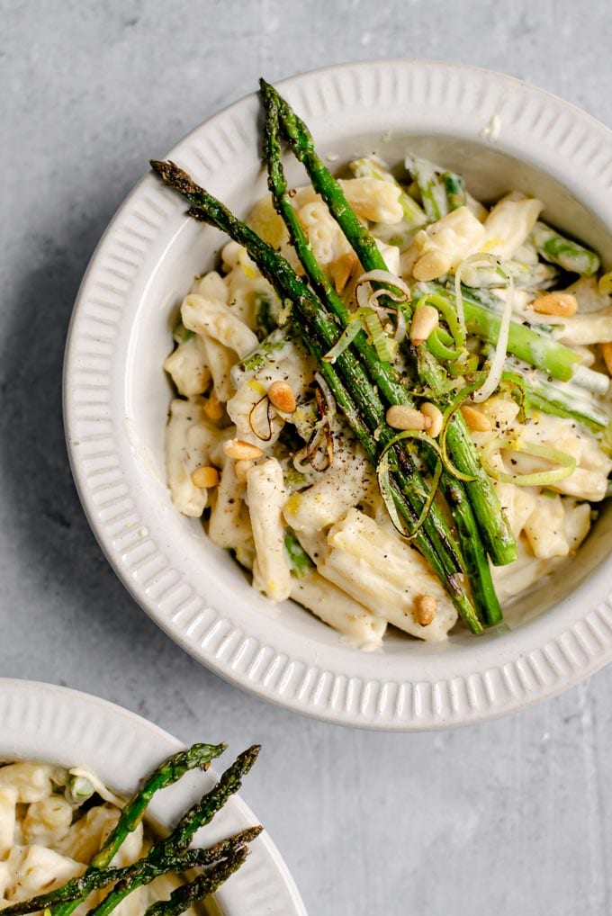 creamy asparagus and leek pasta garnished with asparagus spears and served in two bowls