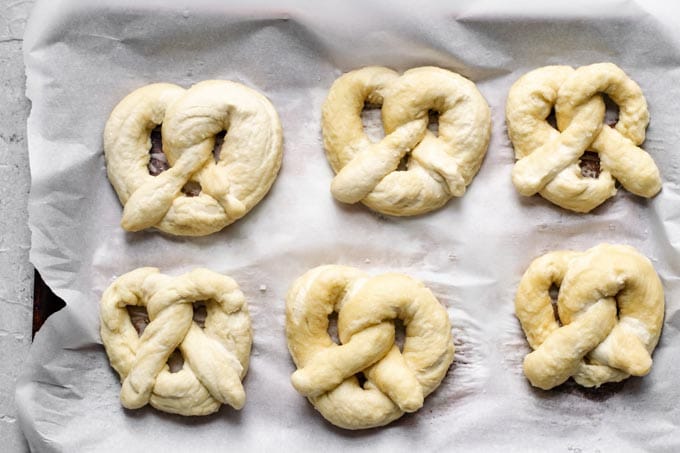 homemade soft pretzels shaped and boiled in a baking soda bath and ready to bake