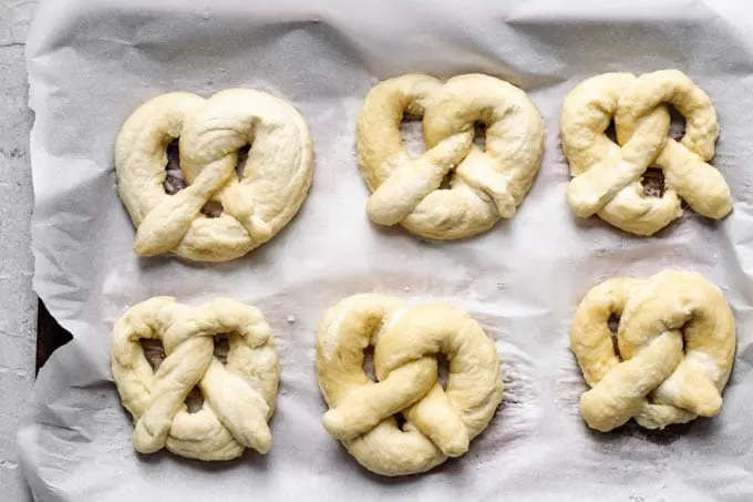 homemade soft pretzels shaped and boiled in a baking soda bath and ready to bake