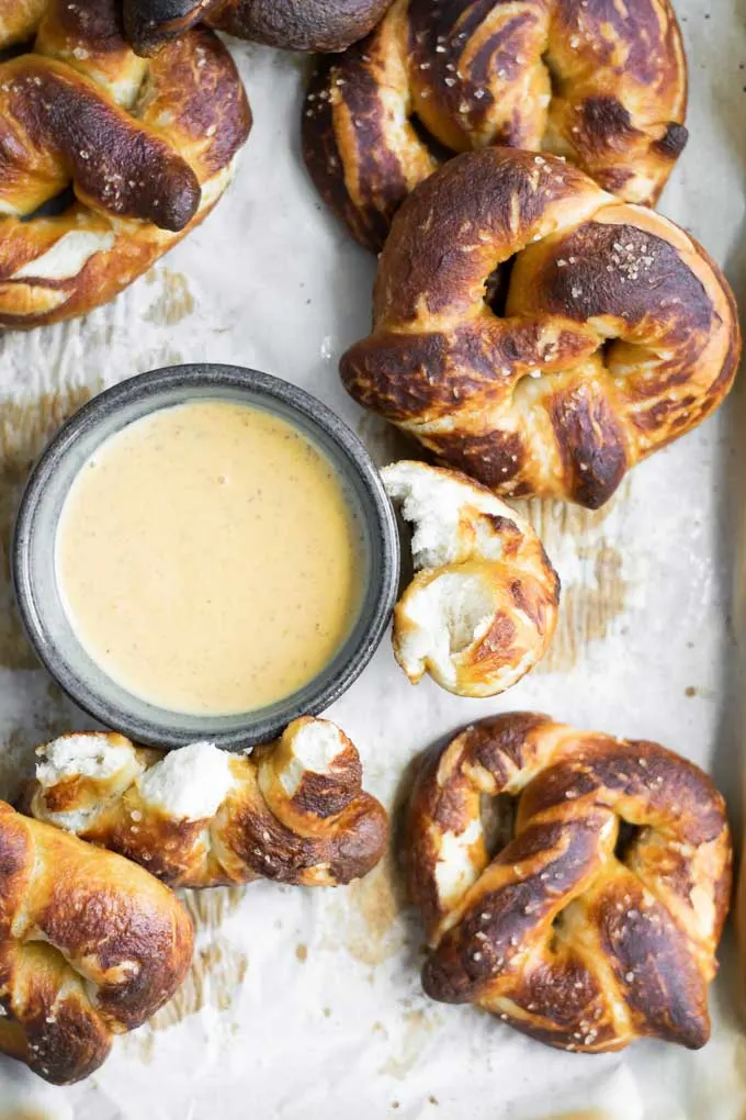 homemade soft pretzels, with one ripped and served with a mustard beer dip
