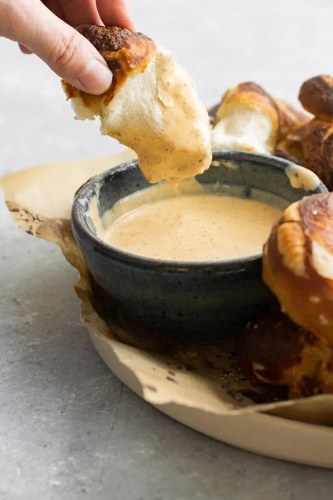 homemade soft pretzel dipped in a mustard beer dip