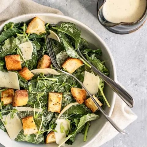 vegan classic caesar salad with baby kale, vegan parmesan, homemade croutons, and homemade vegan caesar dressing