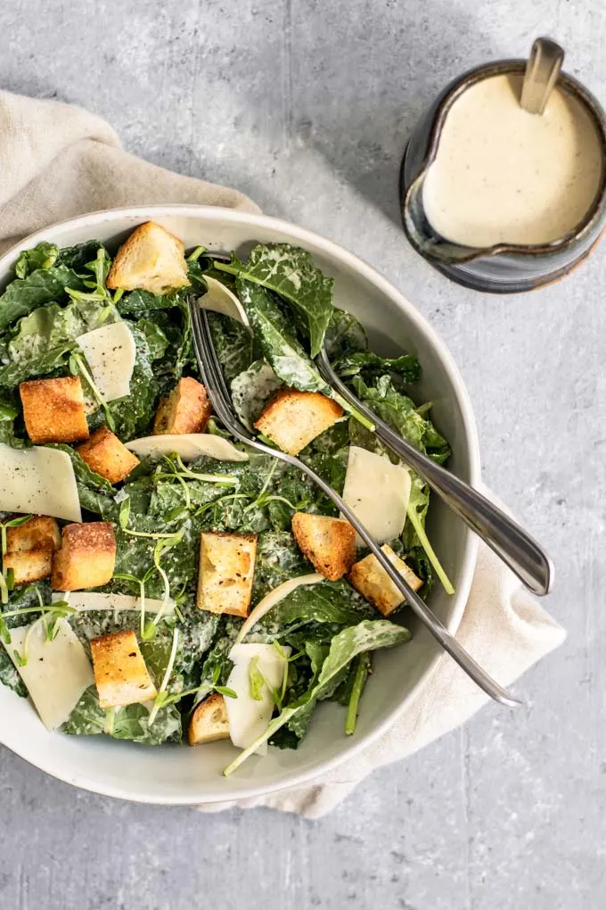 vegan classic caesar salad with baby kale, vegan parmesan, homemade croutons, and homemade vegan caesar dressing