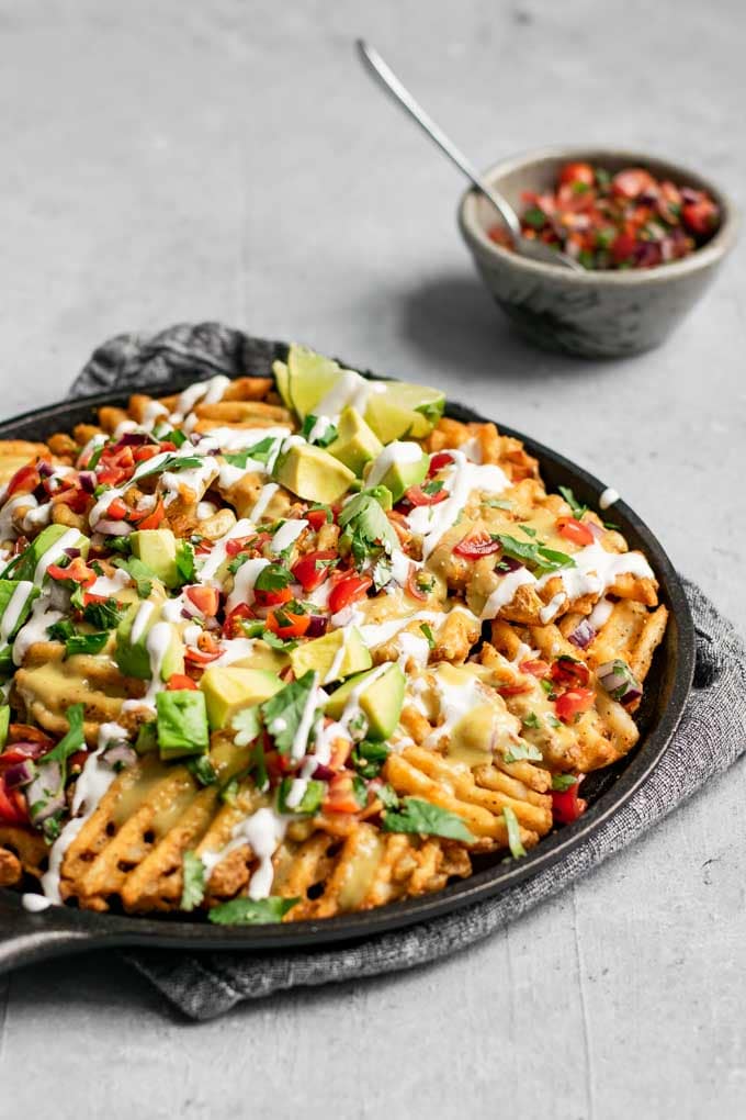 waffle fry nachos with vegan queso, pico de gallo, sour cream, and avocado