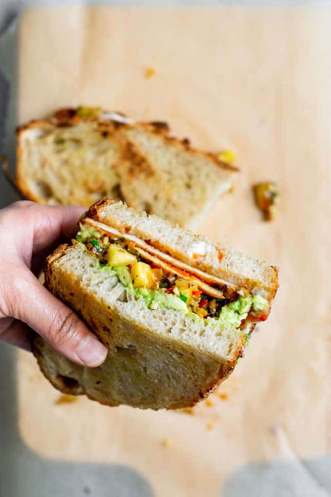 sliced barbecue tofu sandwich with one half picked up to show the filling