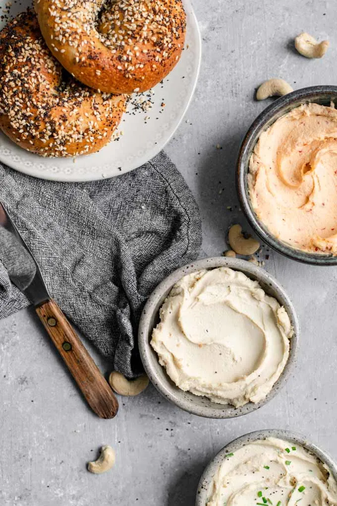 Overhead view of bagels and three flavors of vegan cultured cashew cream cheese