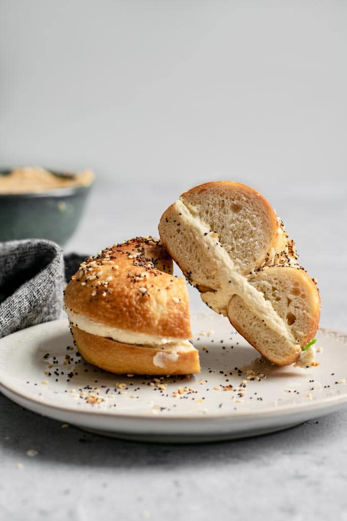 A side on view of a bagel filled with cultured cashew cream cheese