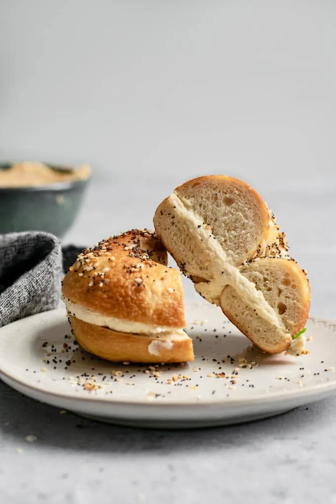 A side on view of a bagel filled with cultured cashew cream cheese