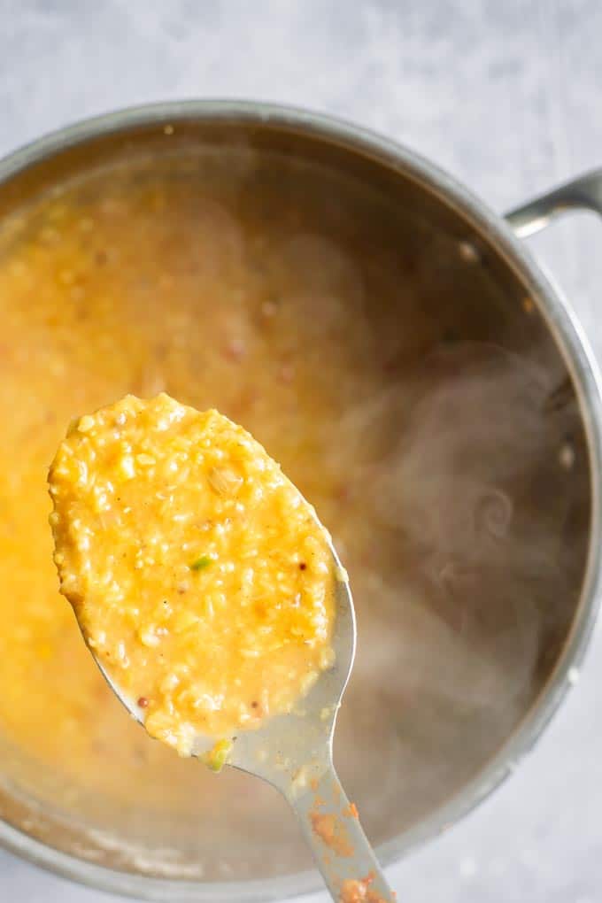 cooked masoor dal tadka in a pot, with a spoon lifted to show detail