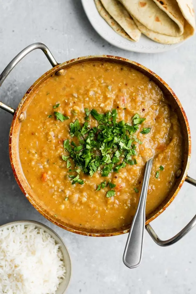 masoor tadka dal served garnished with cilantro and a side of basmati rice and chapati