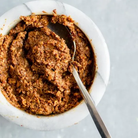 massaman curry paste, prepared and in a white bowl with a spoon in it.