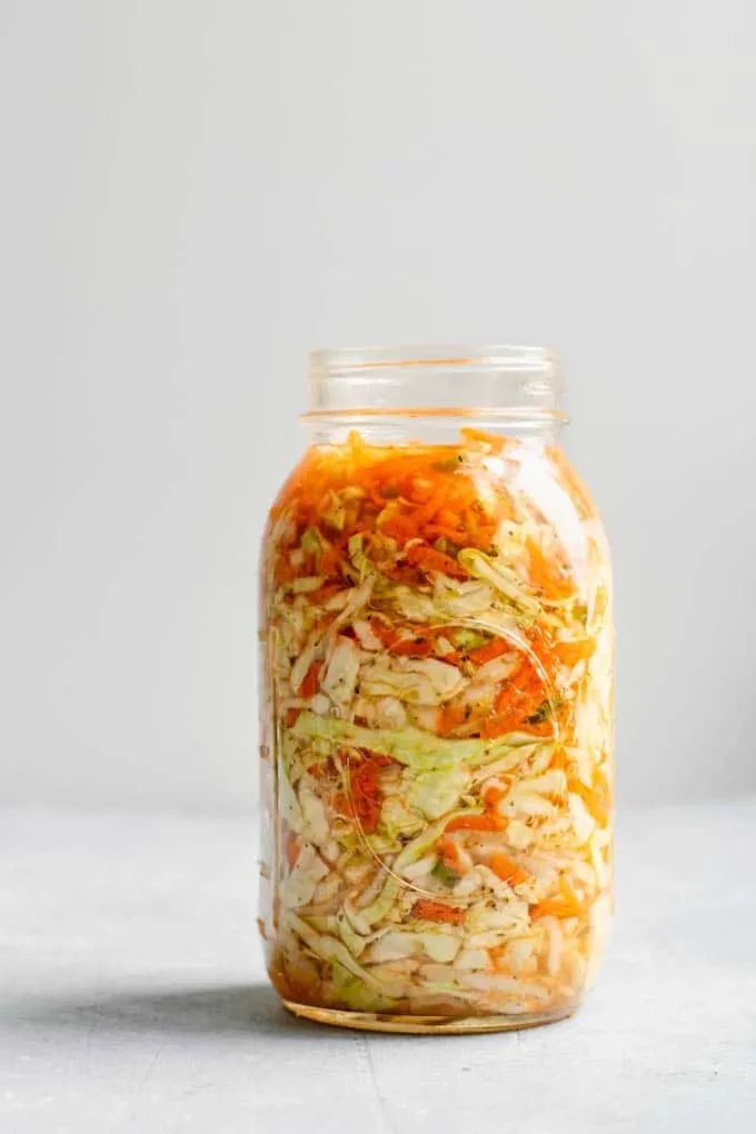 view of the tightly packed curtido in a wide mouth quart sized mason jar