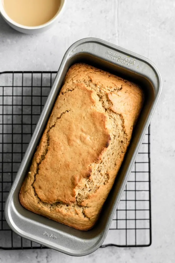 chai spice loaf cake in the loaf pan cooling on a wire rack