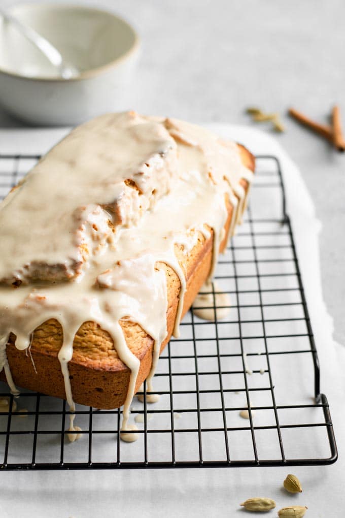 vegan chai spice loaf cake being glazed with the chai glaze