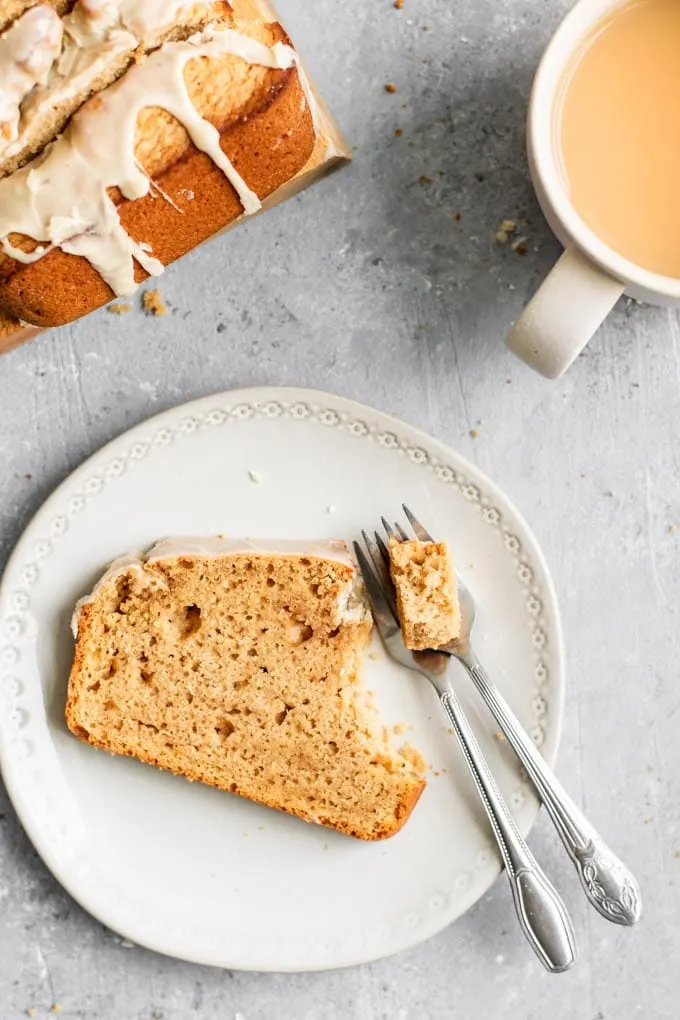 A slice of chai spice loaf cake with a fork taking a bite out of it